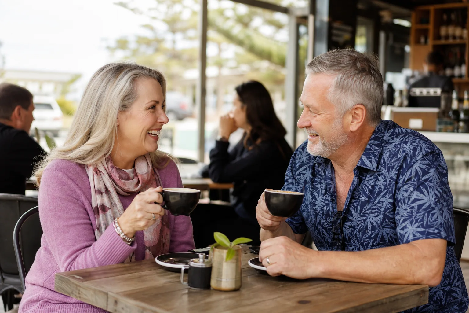 Two people over 50 talking at an outdoor Melbourne café